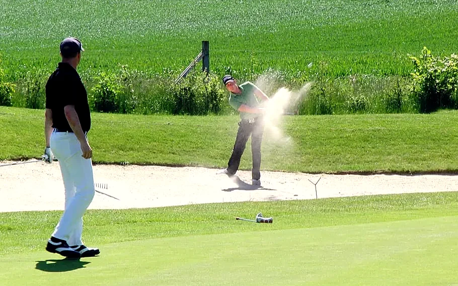 Golfers dressed smart casual on a bunker shot